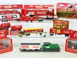 six coca cola trucks and a train in a display case