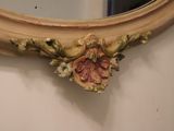 a mirror on the wall with a flower decoration on it