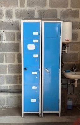 deux casiers bleus situés à côté d'un lavabo dans une pièce