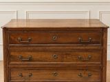 une commode en bois posée sur un parquet dans une pièce