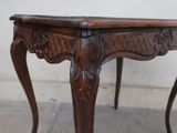 a wooden table with a carved top and legs