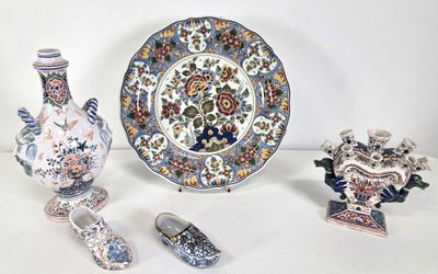 three vases, a plate, and a pair of shoes sitting on a table
