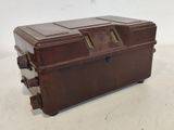 une vieille valise marron posée sur une table blanche