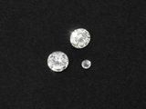 un gros plan sur trois diamants posés sur une surface noire