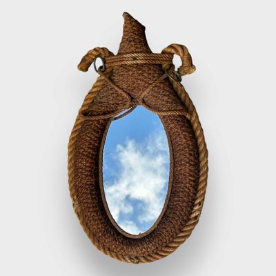 un miroir entouré d'une corde, avec le ciel en arrière-plan