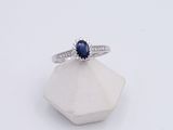an image of a ring with a blue sapphire stone on top of a white rock