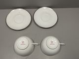 three cups and a saucer are sitting on a table