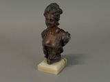 bronze bust of a woman with a hat on a marble base