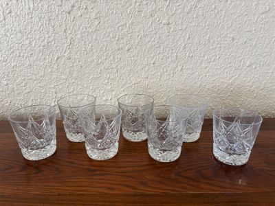 four glasses on a table with a white wall in the background