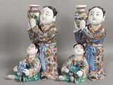 three figurines of asian women and a baby are posed for a picture