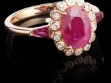 un gros plan d'une bague en saphir rose et diamants posée sur une surface noire