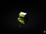 a close up of a green crystal on a black surface