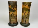 two vases with trees painted on them sitting on a table