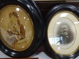two framed pictures of a man and a woman on a table