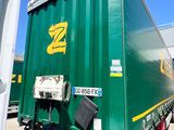 a green semi truck that is parked on the side of the road