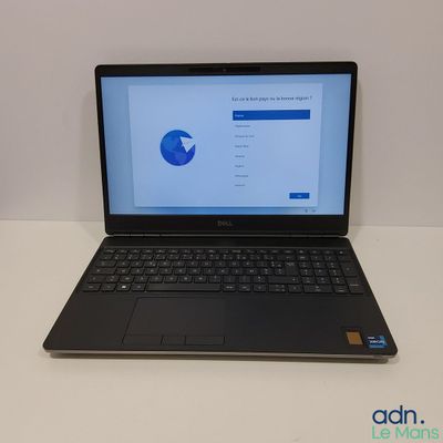 L'ordinateur portable est posé sur la table, l'écran ouvert.