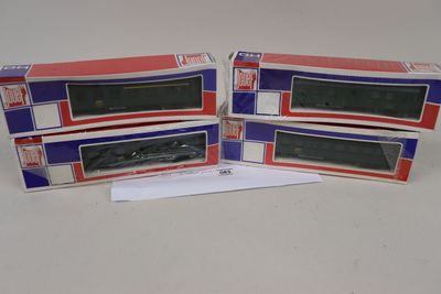 trois cartons contenant des trains miniatures posés sur une table