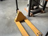 un chariot élévateur au milieu d'une pièce, sur lequel il y a beaucoup de travail à faire