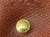 a close up of a brown purse with a gold button on it