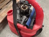 un souffleur rouge posé par terre à côté d'une palette