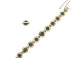 a close up of a gold bracelet with black stones on it