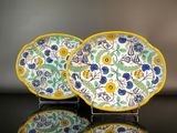 two plates with flowers on them sitting on a table