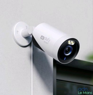 une caméra blanche fixée sur le côté d'un immeuble