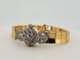 a close up of a gold bracelet with diamonds on it