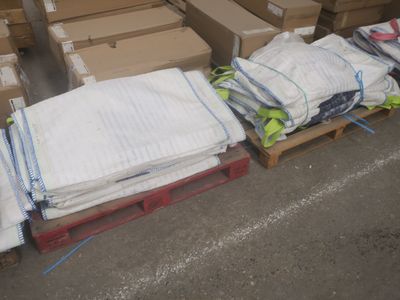 de nombreux cartons et sacs de vêtements posés sur une palette
