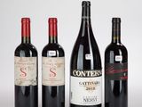 trois bouteilles de vin rouge sont posées les unes à côté des autres sur une surface blanche