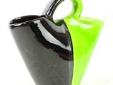 a black and green vase with a handle on a white background