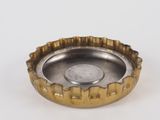 a silver and gold metal ashtray with a coin in the middle