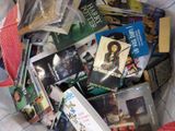 une pile de livres et de DVD sur un lit