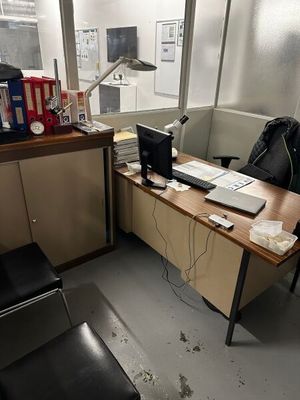 un bureau avec un ordinateur portable et une chaise dans une pièce