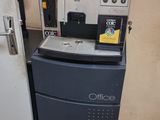 une machine à café posée à côté d'un réfrigérateur dans une pièce