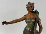bronze statue of a woman holding a violin on a marble base