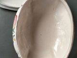 a bowl and a spoon on a table next to each other