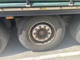a flat tire on the back of a green truck