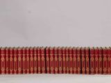 a group of red books sitting on top of a white table