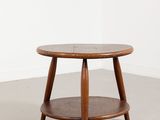 une table basse ronde avec un piètement en bois dans une pièce blanche
