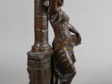 bronze statue of a woman leaning on a pillar with a vase in her hand
