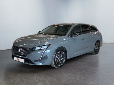 La voiture bleue est garée dans une pièce blanche au sol noir.