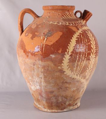 un grand vase muni d'une anse, posé sur une table