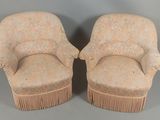 une paire de fauteuils rembourrés beiges ornés de franges