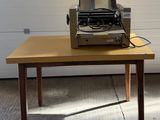 une machine à écrire posée sur une table devant la porte d'un garage