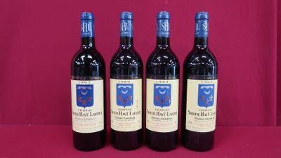 three bottles of red wine are lined up on a pink surface