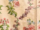a close up of a quilt with flowers and leaves on it