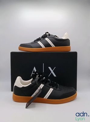 une paire de baskets noires et blanches à semelles orange