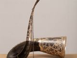 a horn with a chain hanging from it on a table