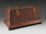 an antique leather trunk with brass hardware on a wooden stand
